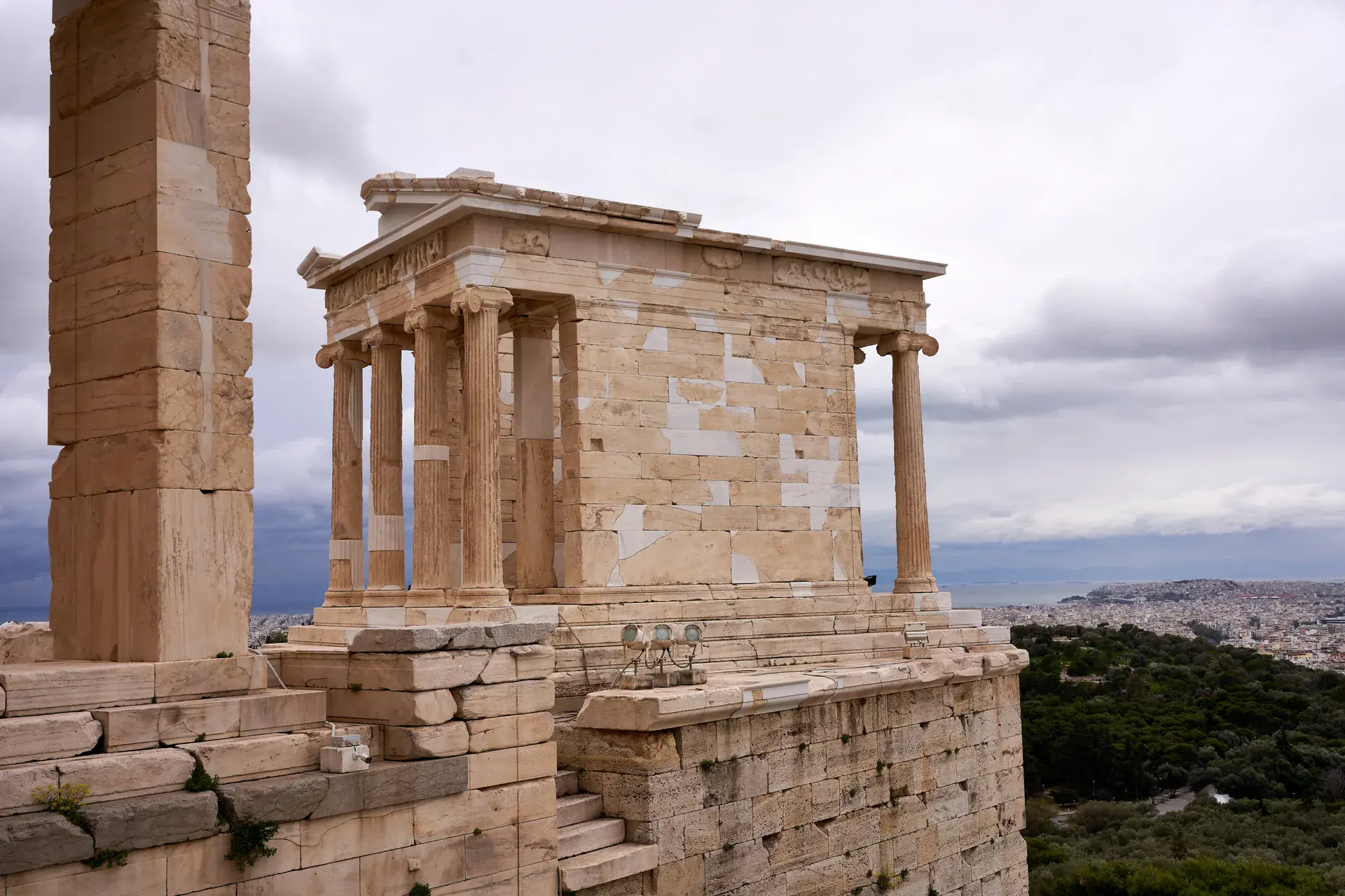 The small Temple of Athena Nike positioned on its defensive bastion with panoramic views over Athens and the sea