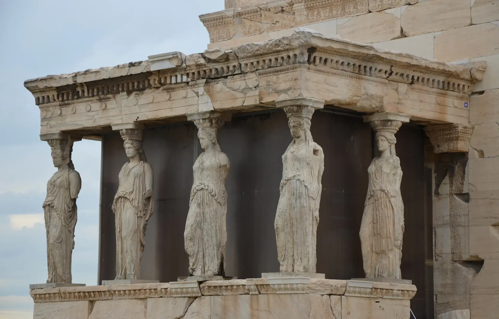 Close-up view of the Caryatid Porch of the Erechtheion showing the six graceful female sculptural columns supporting the temple roof