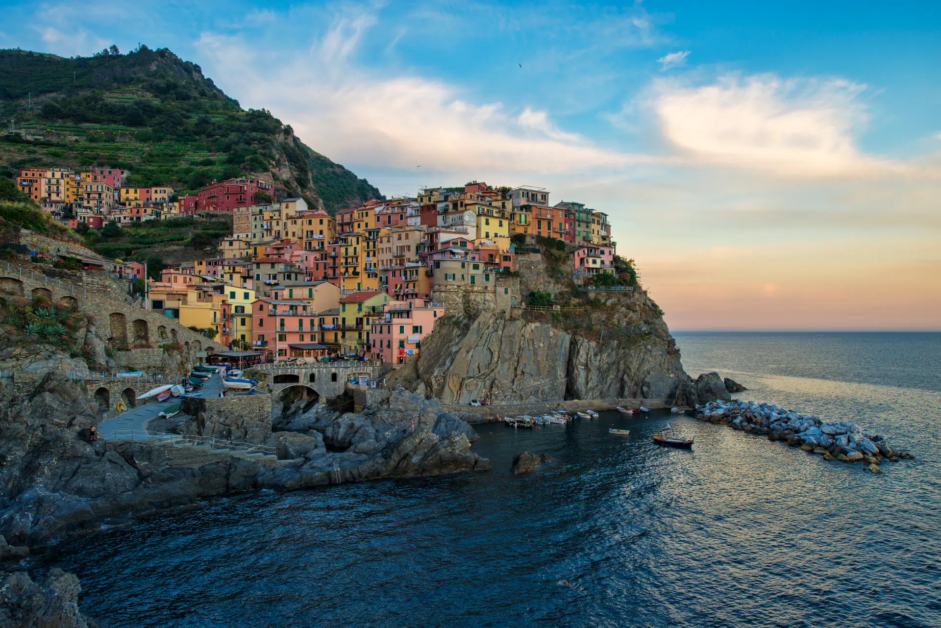 Manarola village illuminated at dusk with colorful houses perched on dramatic cliffs above the Ligurian Sea