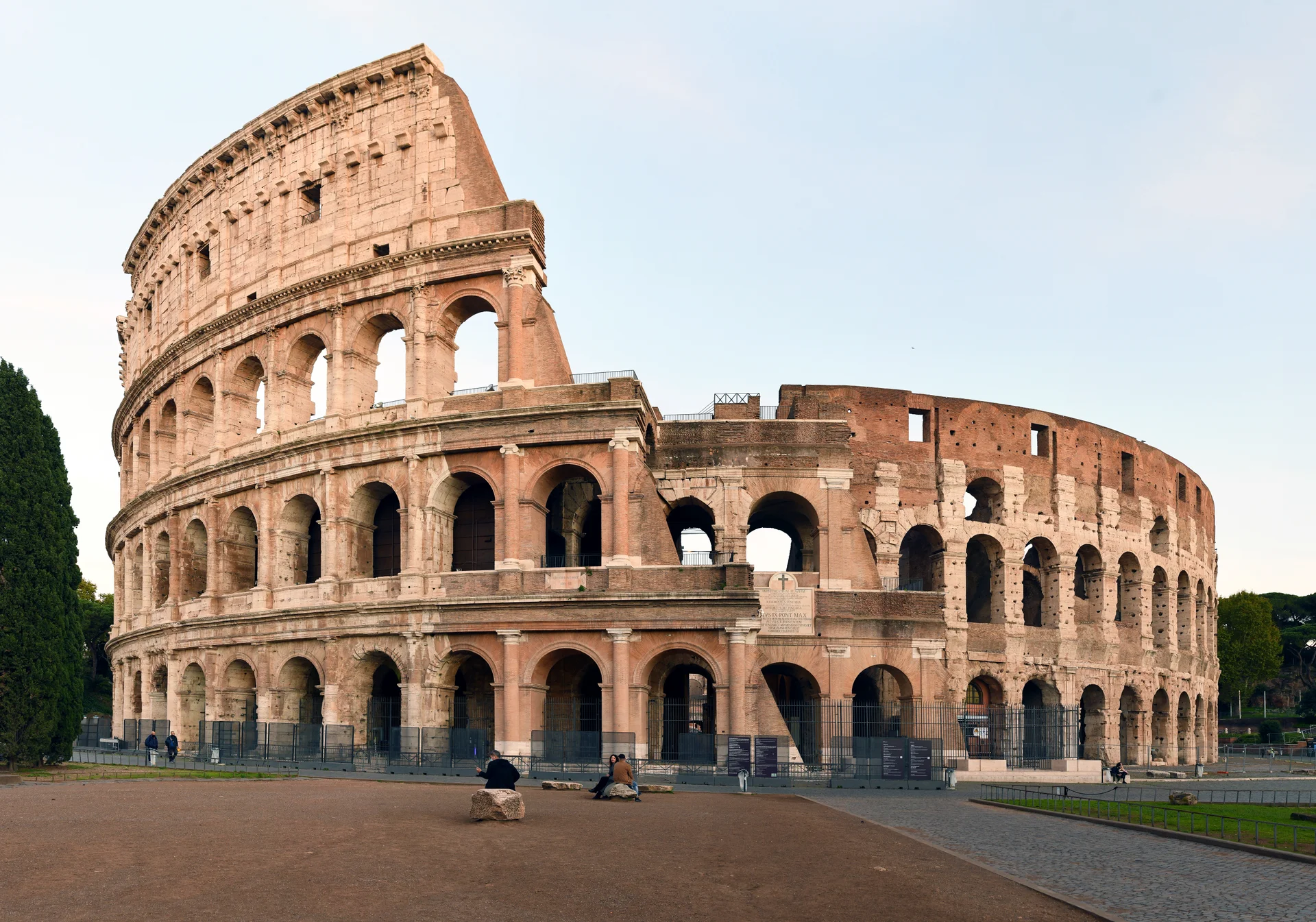 Close-up view of the Colosseum facade showing the three distinct architectural orders with Doric, Ionic, and Corinthian columns in successive tiers