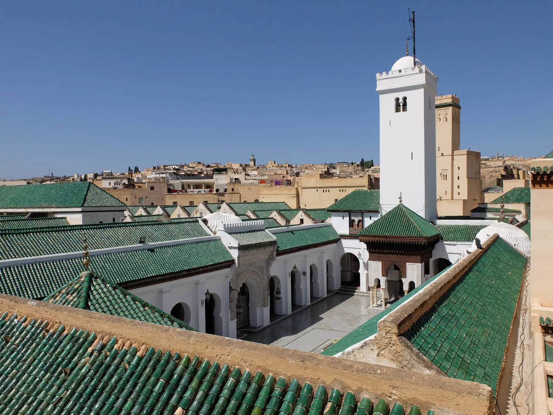 Vista exterior de la Universidad Al-Qarawiyyin mostrando el complejo de mezquita antigua con arquitectura marroquí tradicional y el famoso minarete