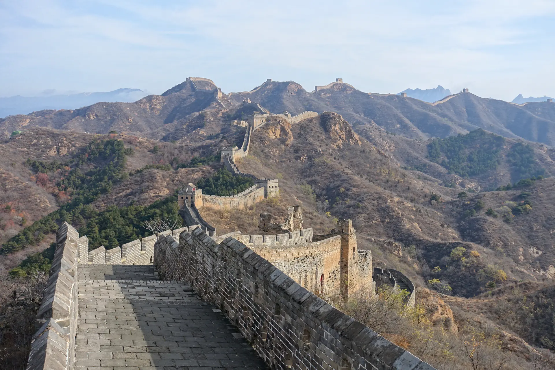 Panoramic view of Great Wall at Jinshanling winding dramatically across mountain ridges with watchtowers serpentining through rugged terrain