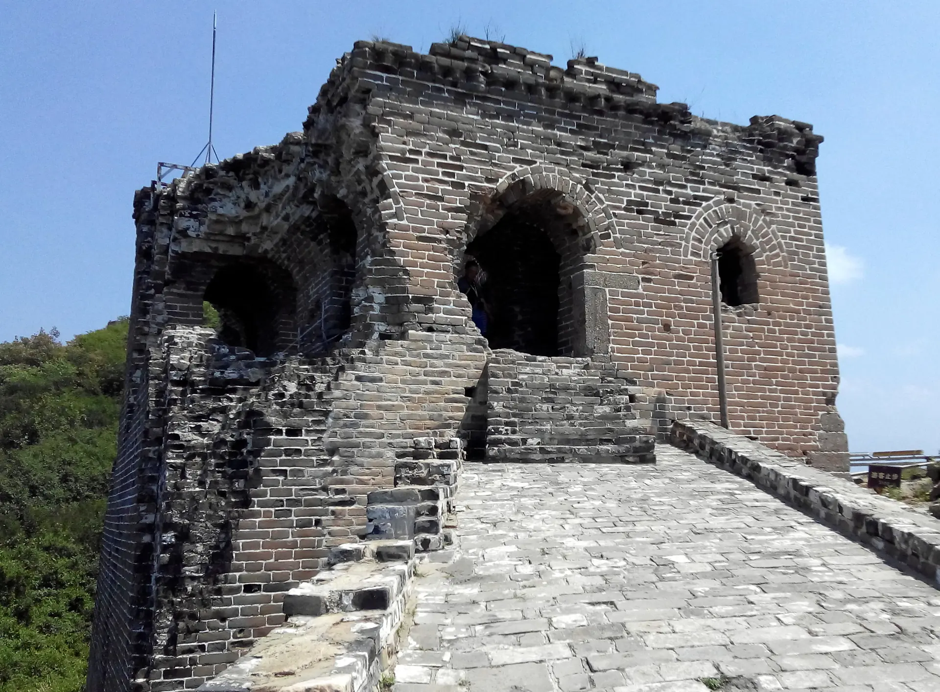 Detailed view of Simatai watchtower showing brick construction, crenellated battlements, and strategic positioning on mountain ridge