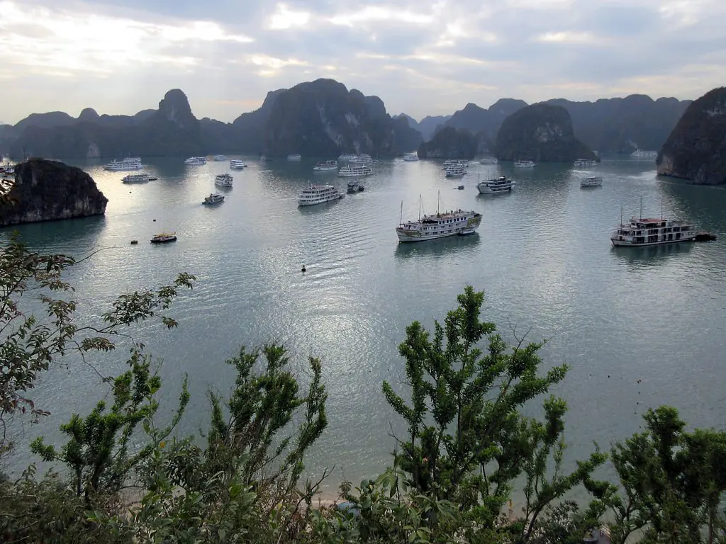 Vista panorámica desde la cima de la Isla Ti Top mostrando cientos de islas kársticas de piedra caliza dispersas a través de las aguas esmeralda de la Bahía de Ha Long extendiéndose hasta el horizonte