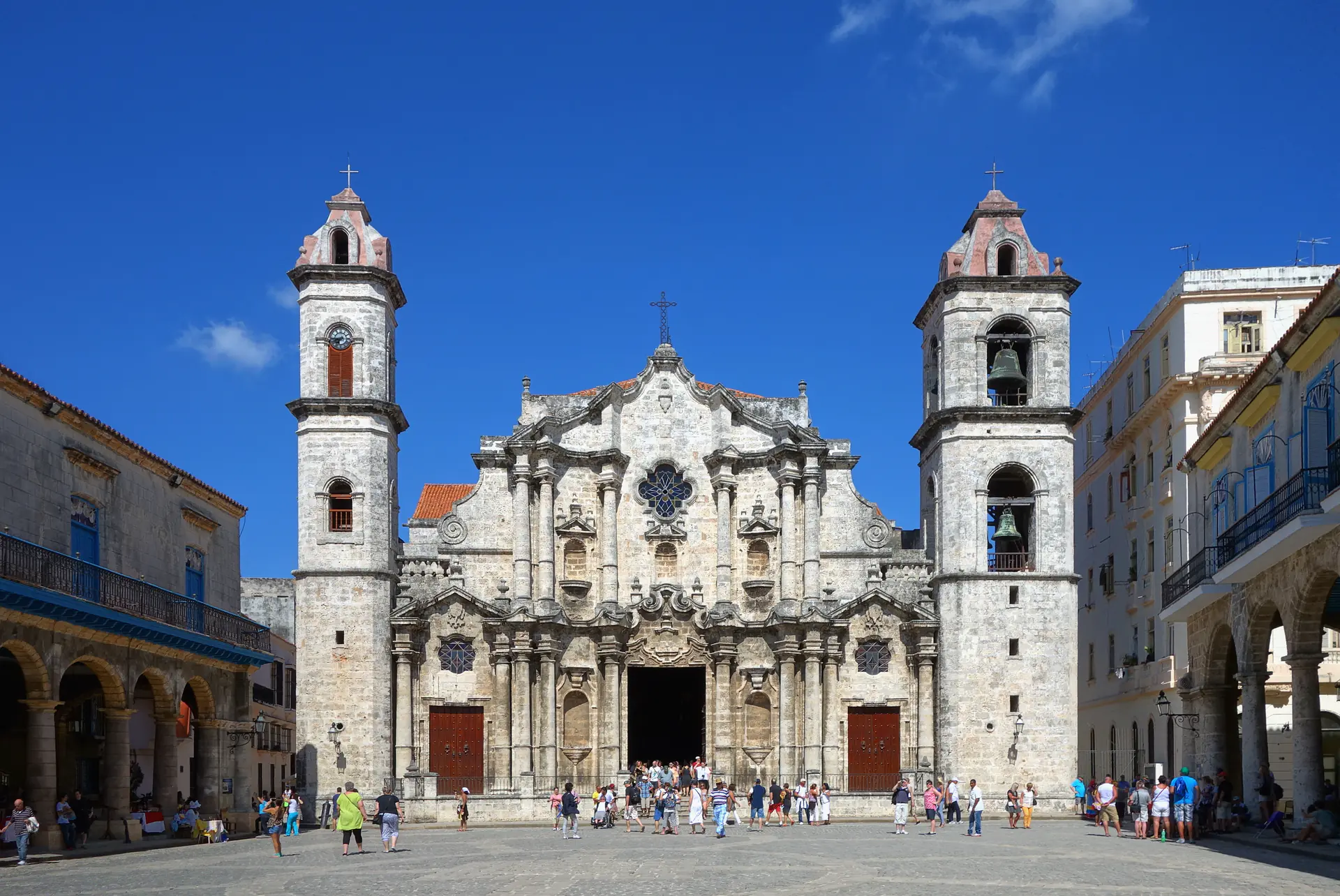 Baroque facade of Havana Cathedral with its distinctive asymmetrical bell towers rising above the intimate Plaza de la Catedral, surrounded by restored colonial mansions