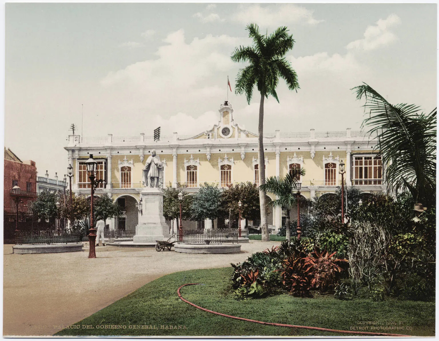 Colorful vintage 1950s American cars parked along a colonial street in Old Havana with restored baroque buildings and palm trees in the background