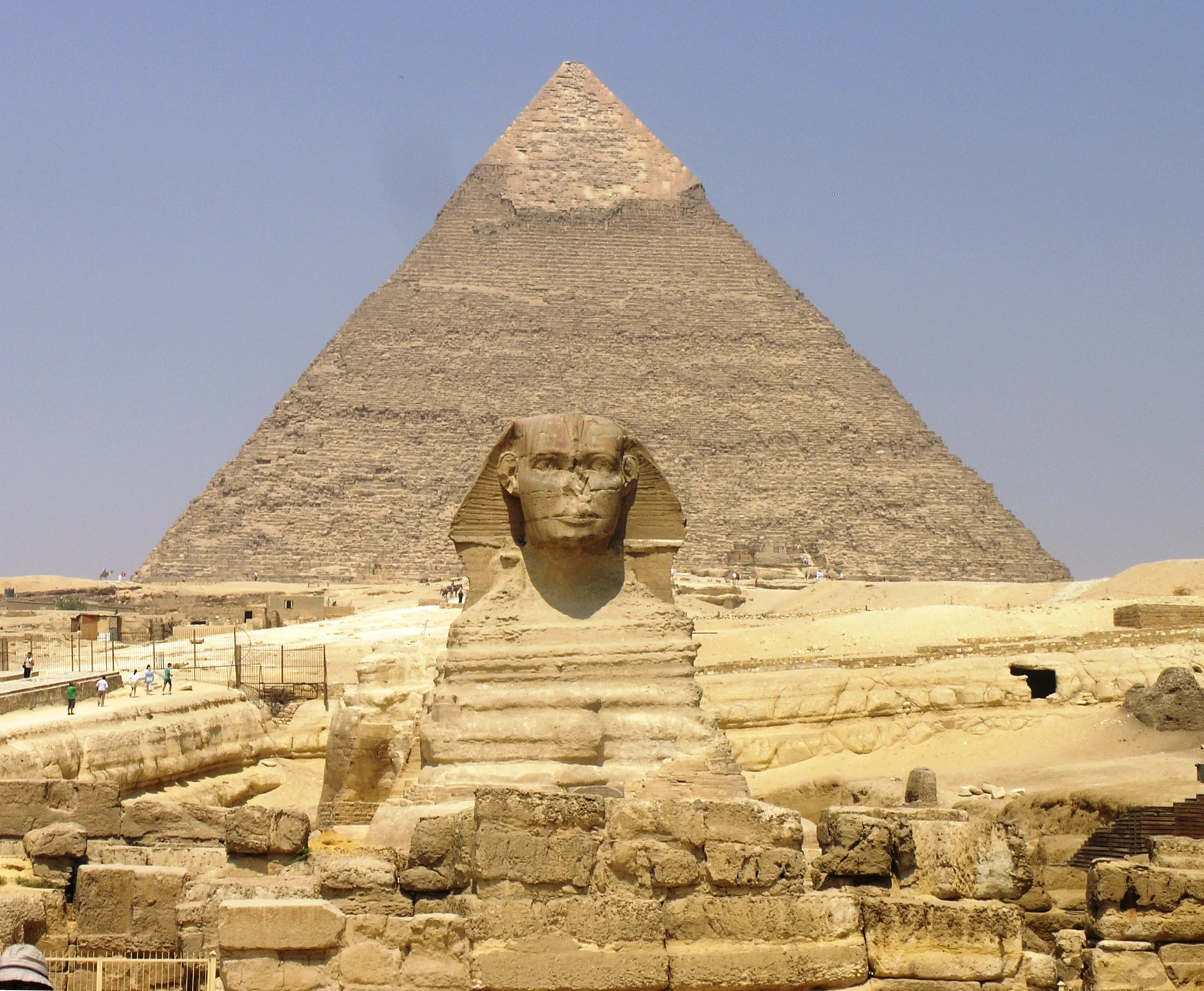 The Great Sphinx of Giza in profile with the Pyramid of Khafre rising behind it, showing the limestone monument guarding the ancient necropolis