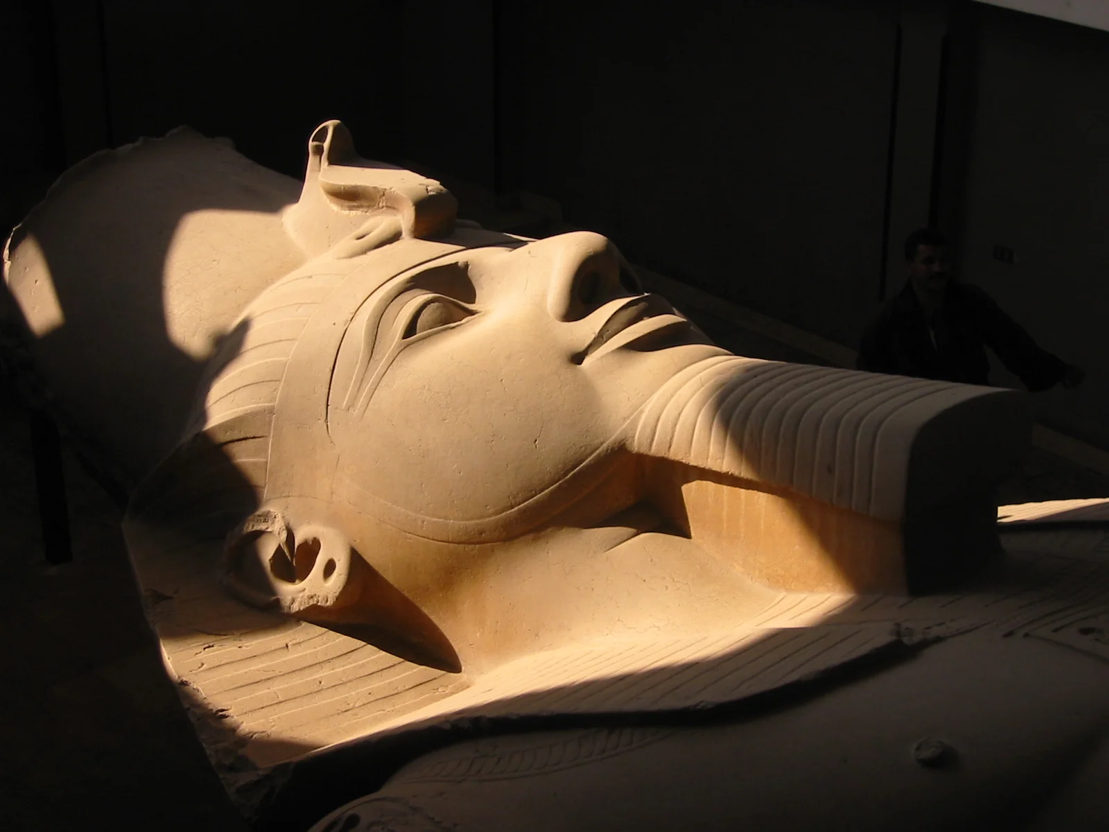 The colossal limestone statue of Ramesses II lying in the open-air museum at Memphis, ancient capital of Egypt with hieroglyphic inscriptions visible