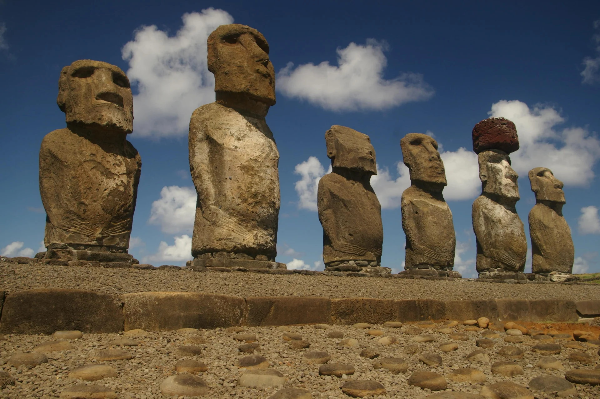 Six of the fifteen moai statues at Ahu Tongariki ceremonial platform standing against blue sky