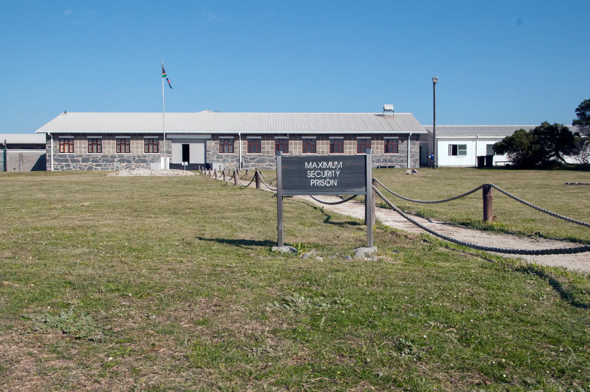 El corredor del bloque de prisión de máxima seguridad Sección B mostrando las puertas de las celdas y la dura arquitectura institucional de la prisión del apartheid