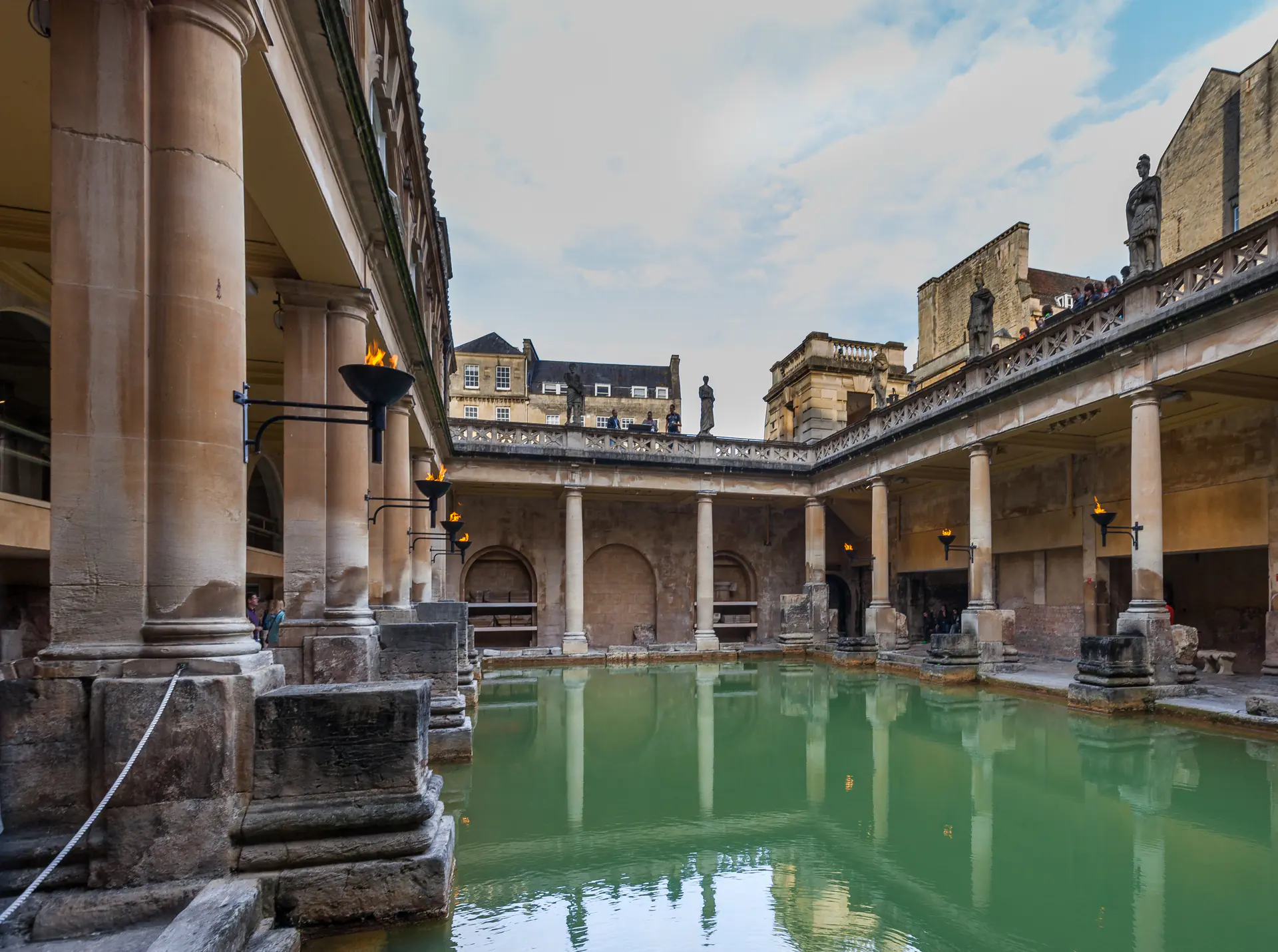 The Roman Great Bath in Bath, England, showing the ancient thermal pool with Georgian terrace architecture and emerald thermal waters