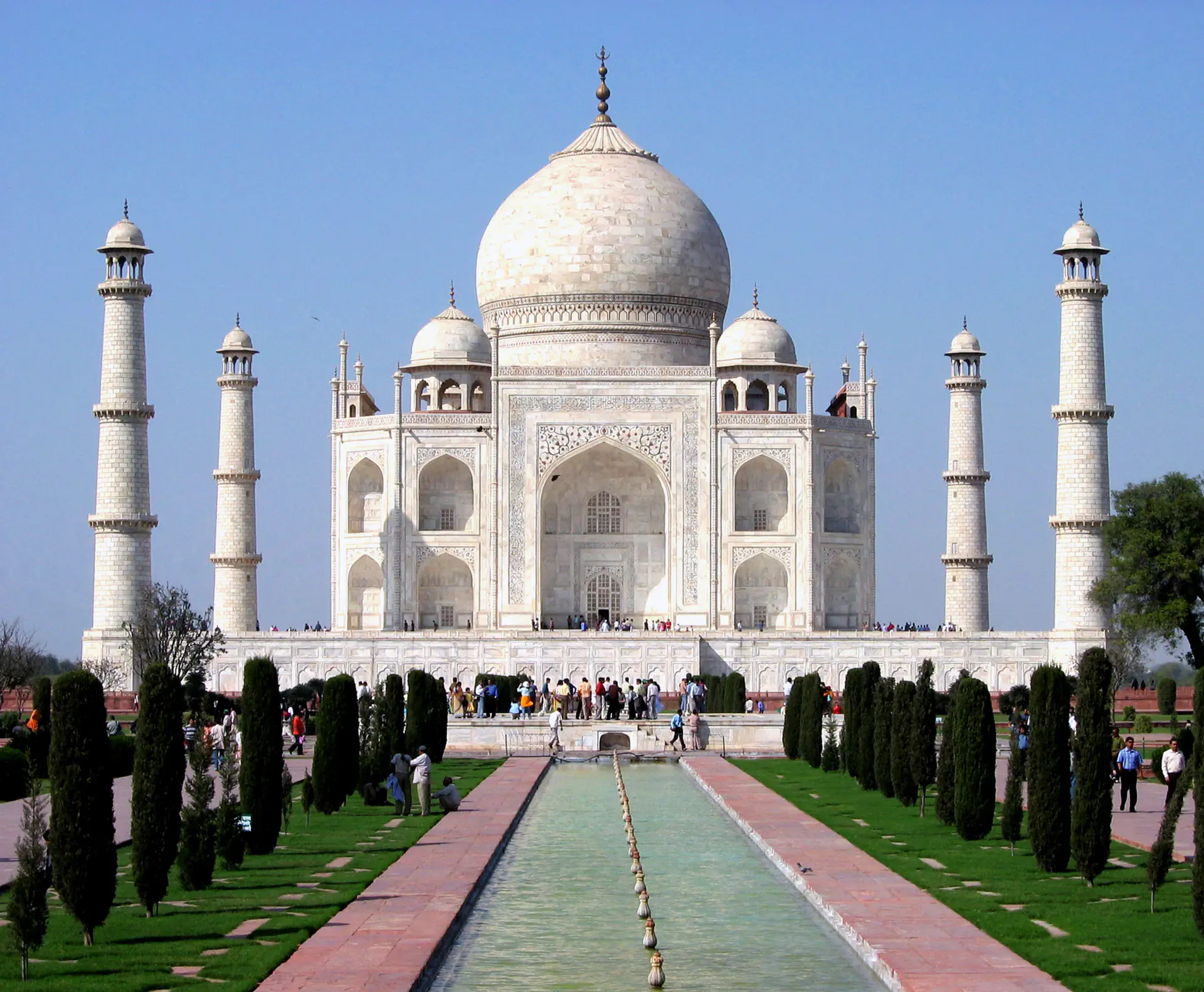Close-up view of the Taj Mahal's pristine white marble facade showing intricate pietra dura floral inlay work and Islamic calligraphy