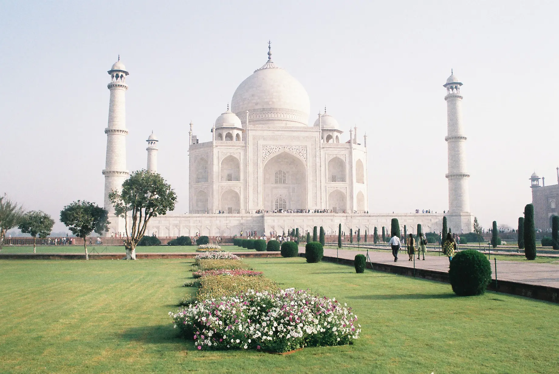 The formal Mughal gardens of the Taj Mahal with geometric water channels and pathways leading to the white marble mausoleum