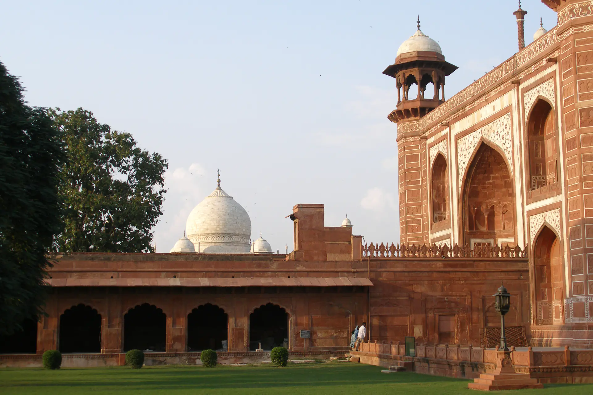 The imposing red sandstone Great Gate entrance to the Taj Mahal complex, adorned with intricate Islamic calligraphy and marble inlay
