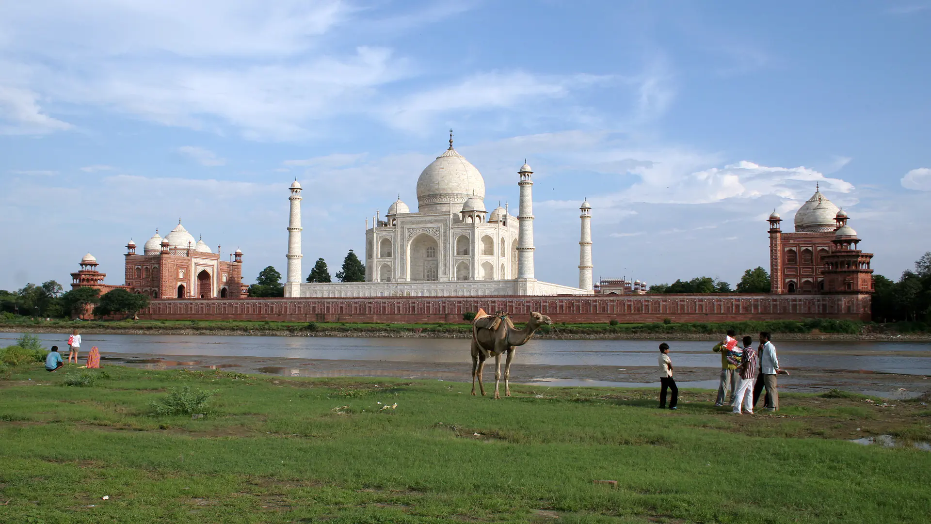 View of the Taj Mahal from across the Yamuna River showing the monument's full elevation and its relationship with the natural landscape