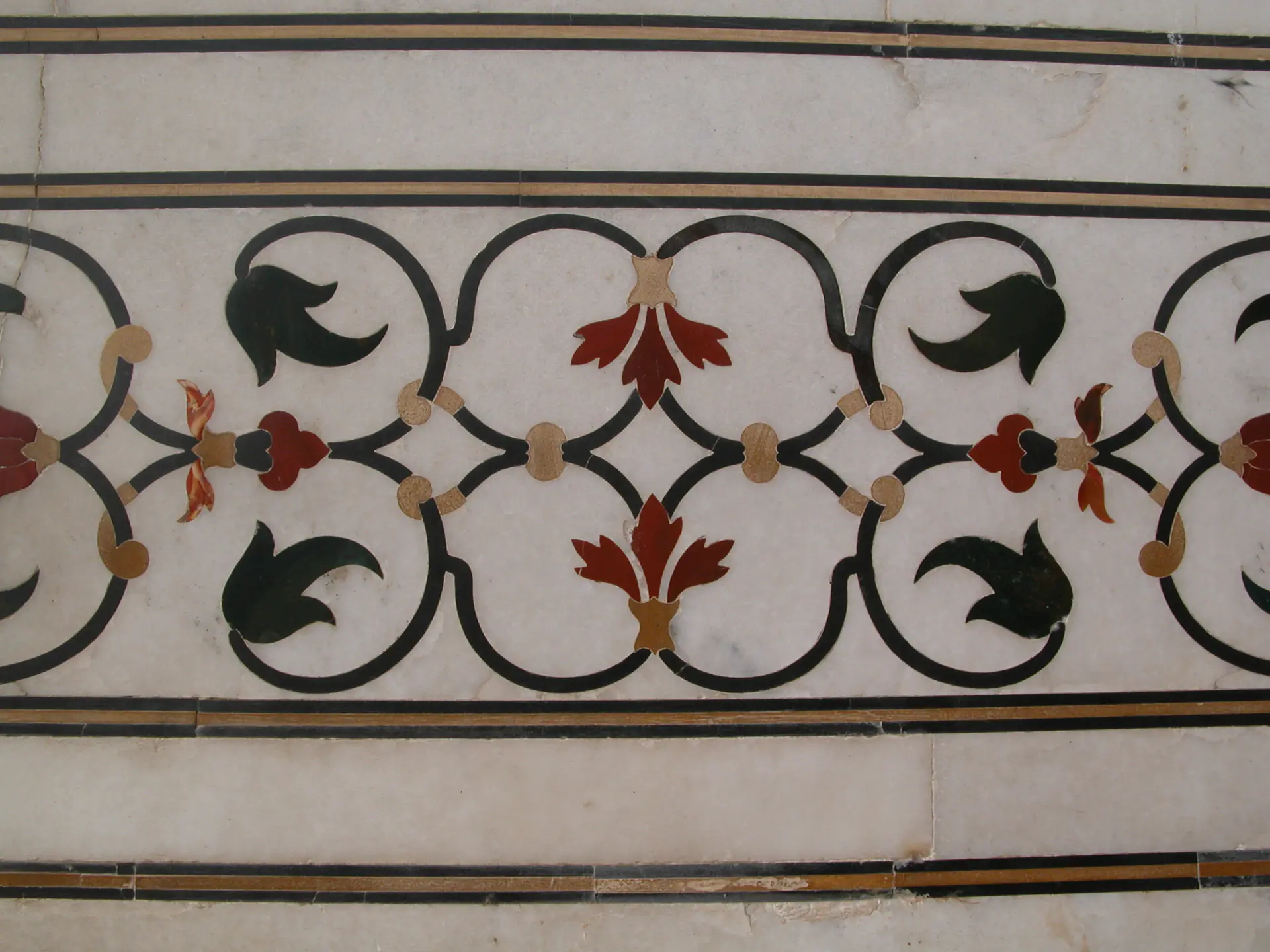 Close-up of ornate floral pietra dura inlay work at Taj Mahal showing detailed stone flower design with semi-precious stones