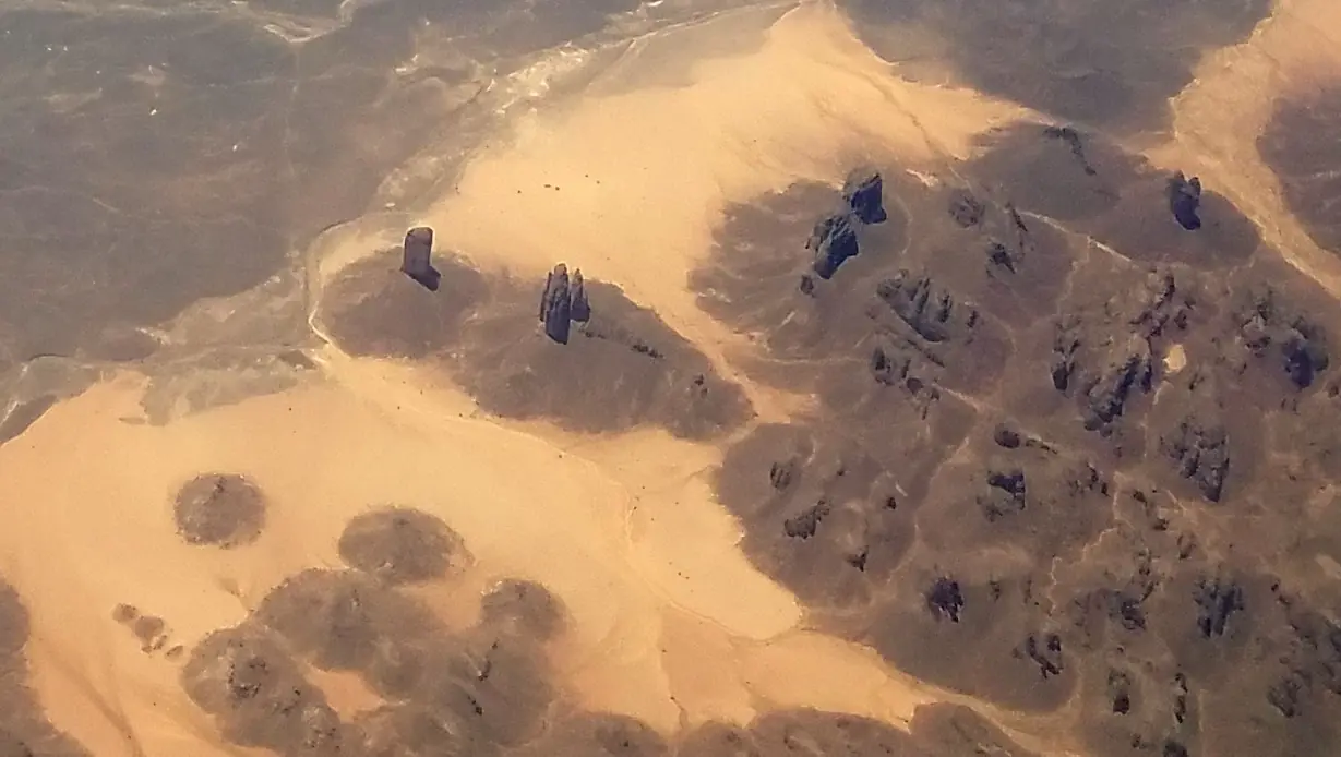 Towering weathered sandstone columns rising from the desert floor showcasing the distinctive eroded rock forest formations of Tassili n'Ajjer