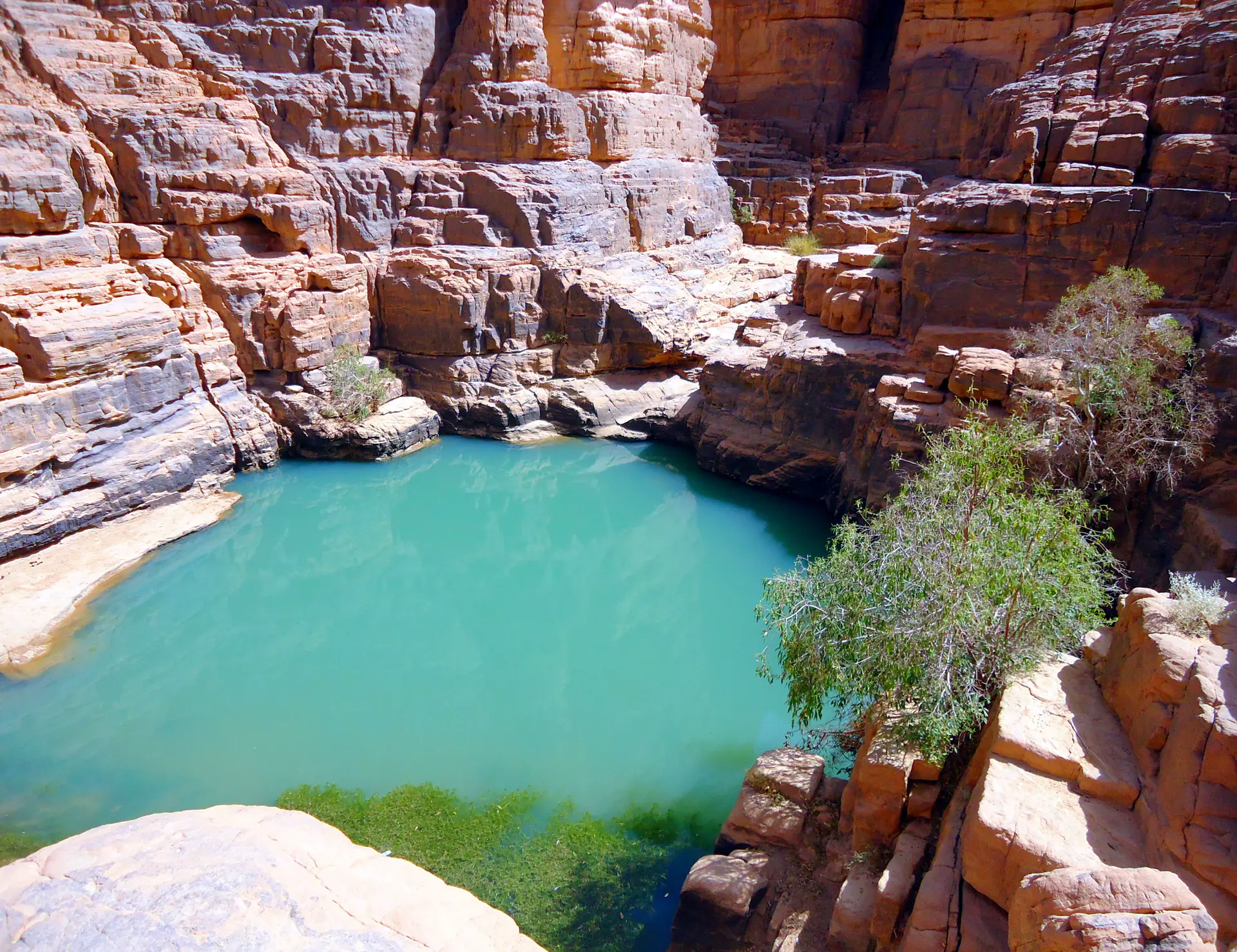 Deep canyon of Tikoubaouine with towering sandstone cliff walls and dramatic geological formations carved by ancient water erosion