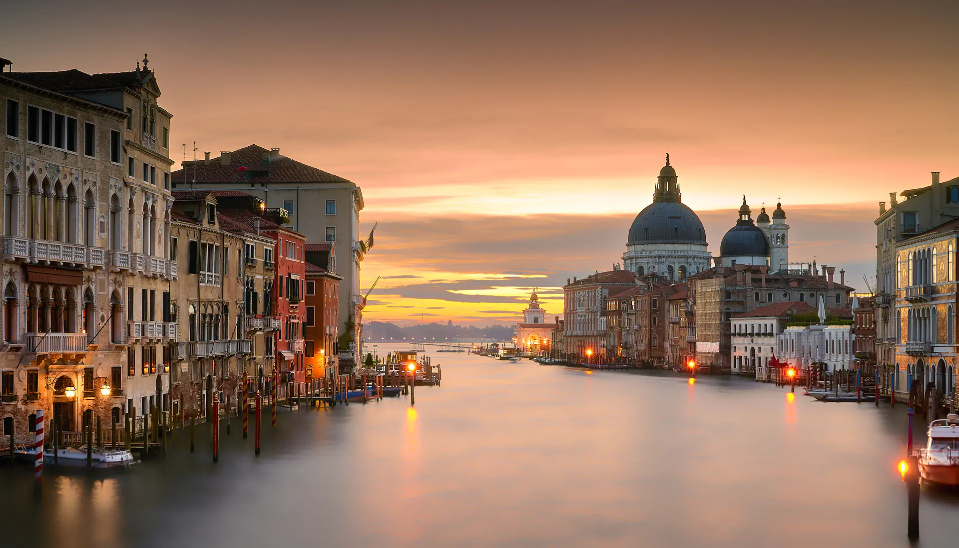 Stunning sunrise over Venice with golden light illuminating the historic architecture and calm waters of the lagoon, capturing the city's serene beauty