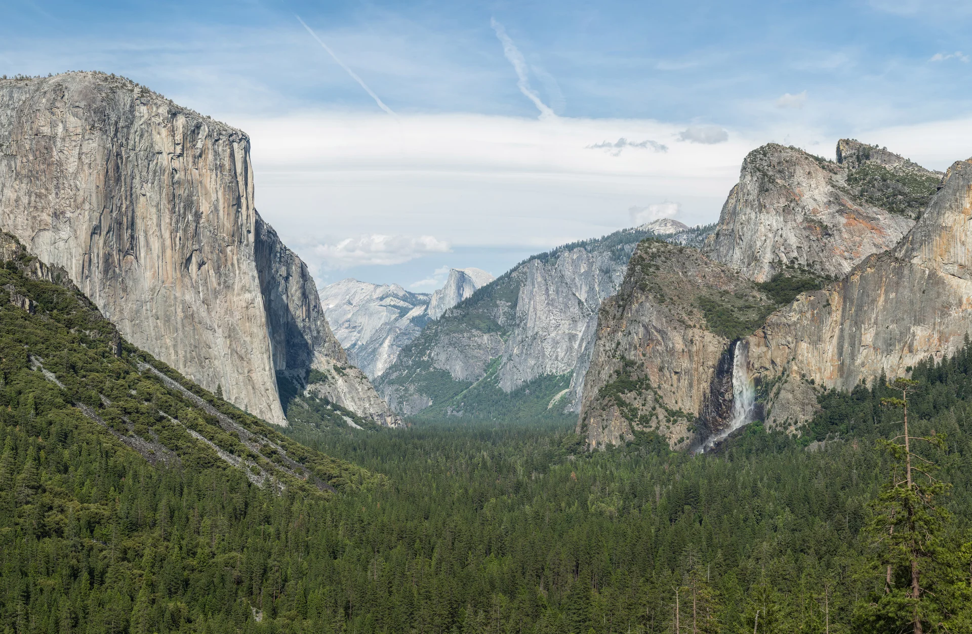 Iconic Tunnel View panorama showing El Capitan, Bridalveil Fall, and Half Dome granite formations in Yosemite Valley